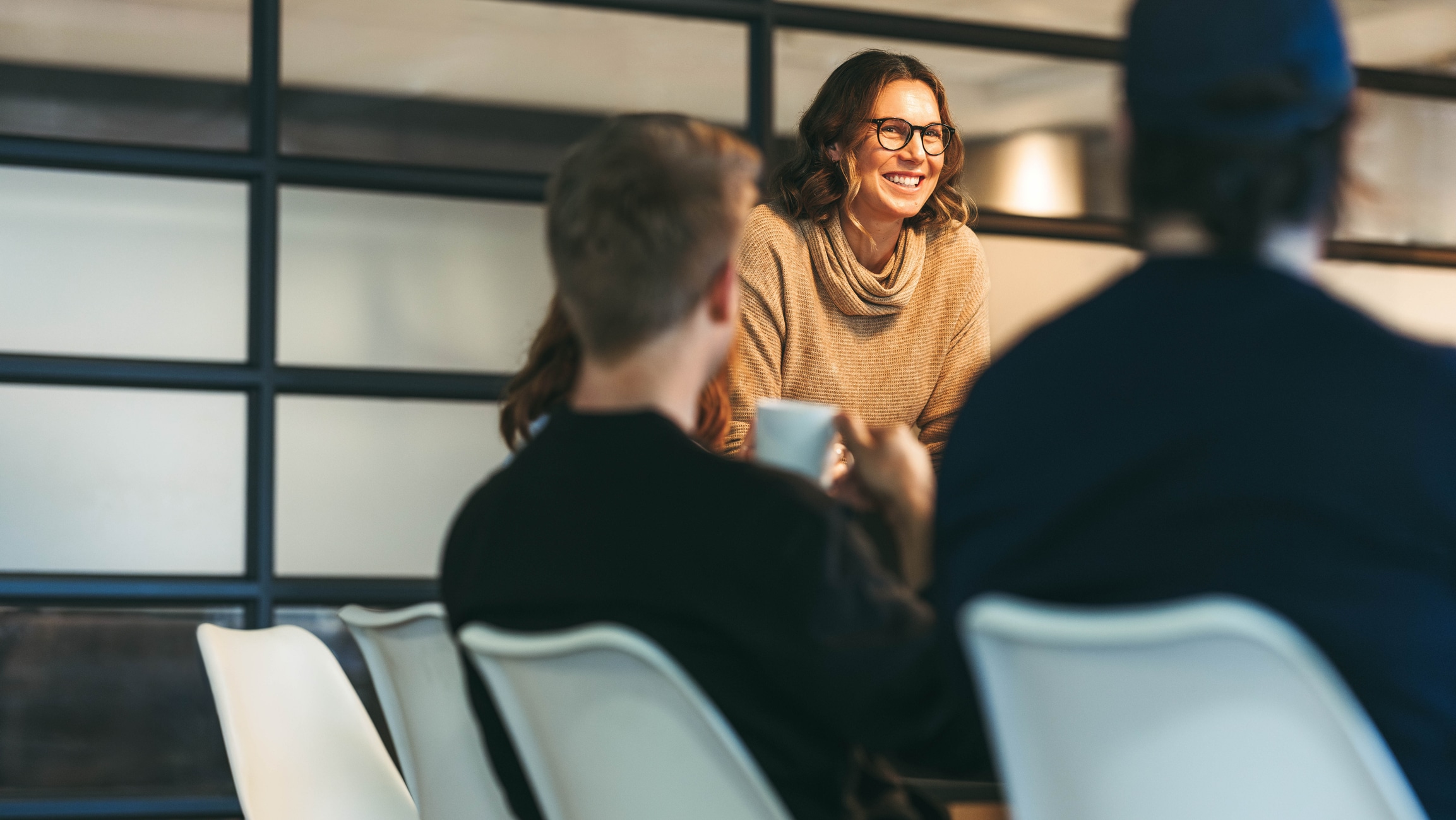 Lady with glasses holds a meeting at a tech company.